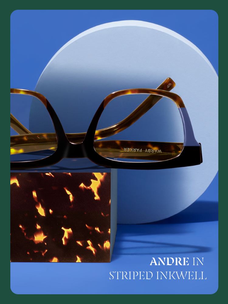 Tortoiseshell glasses in "Striped Inkwell" style, set against bold blue shapes. Text: Andre in Striped Inkwell.