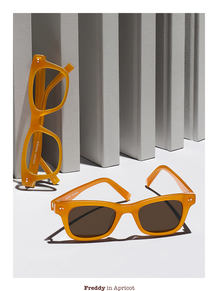 Sunglasses and gasses posing in front of white books.