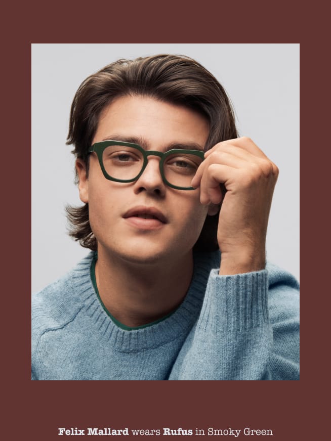 Man posing with hand holding glasses.