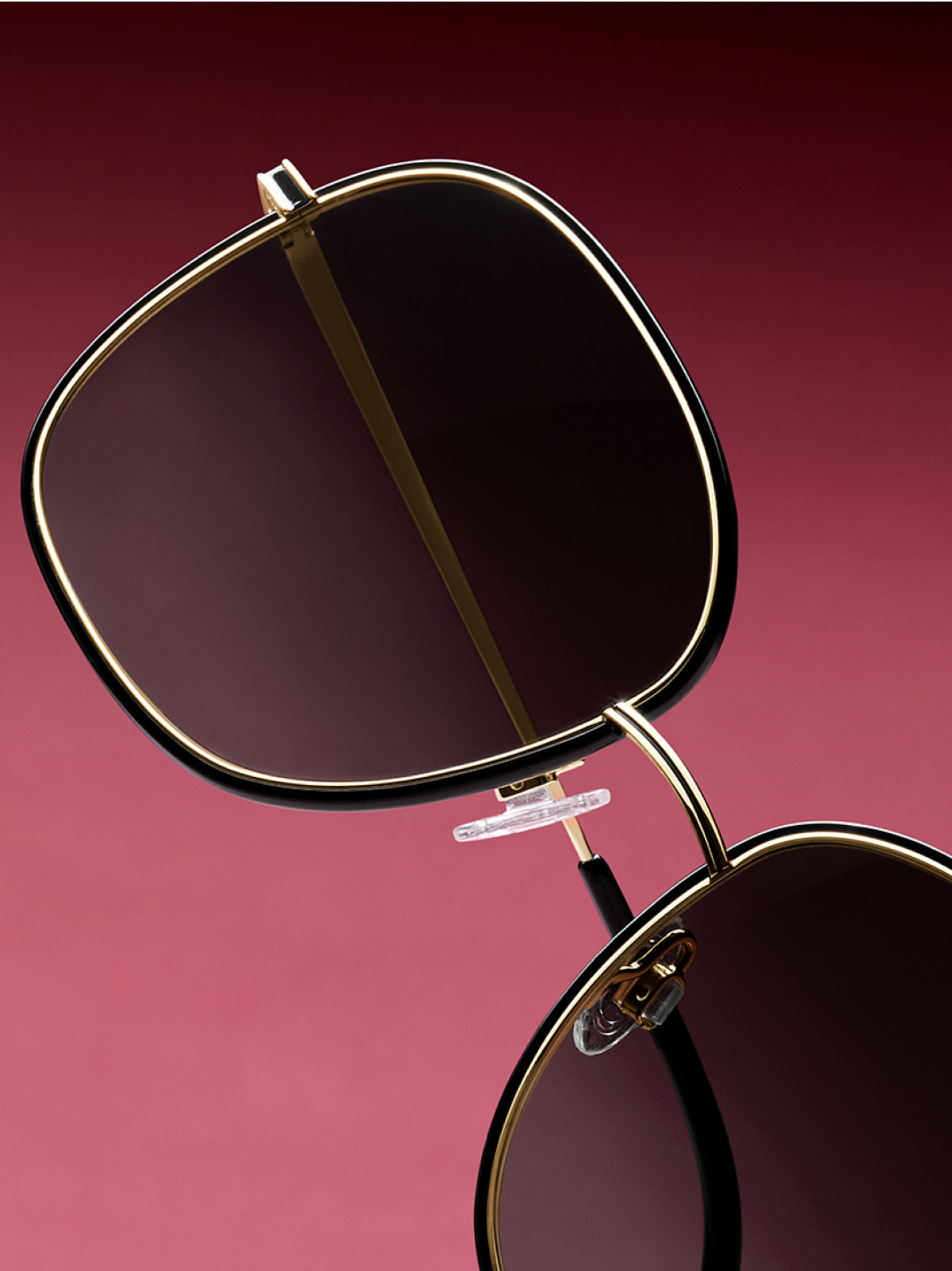 Close-up on Leah glasses against a gradien red background.