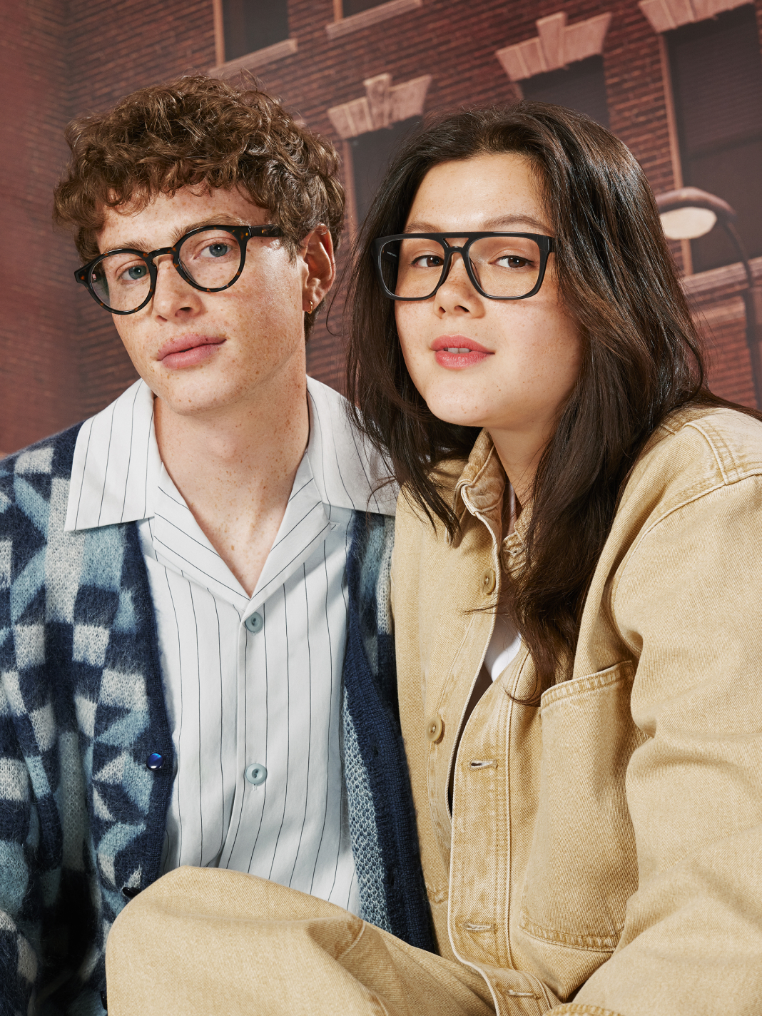 From left to right: Model wears the Peter Parker eyeglasses in Pumpernickel Tortoise, and model wears the Miles Morales eyeglasses in Shadow.