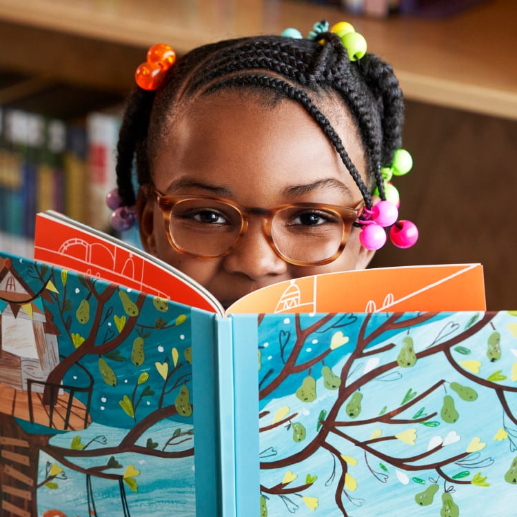 Little kid smiling while holding a children's book