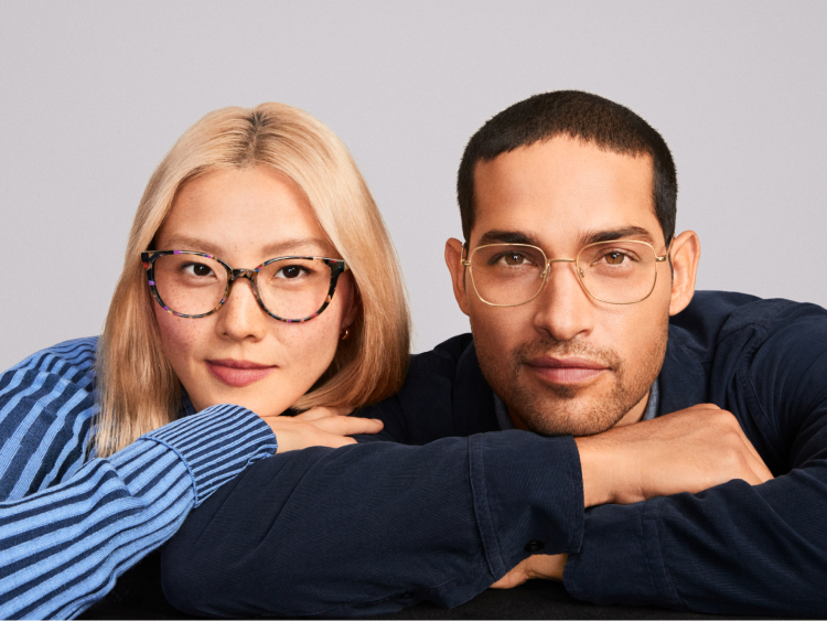 Model at left wears the Elodie frame in Pink Robin Tortoise. Model at right wears the Gifford frame in Polished Gold.