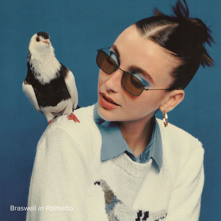 Emma Chamberlain wears the Braswell frame in Palmetto. A debonair pigeon poses on her shoulder.