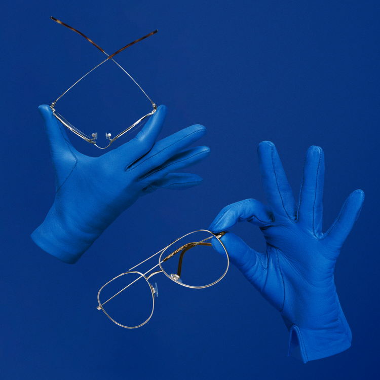 Blue gloves holding up frames showing its bendable construction