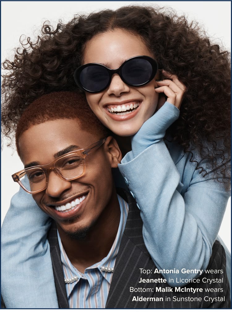 Two person wearing glasses and sunglasses leaning into each other smiling.