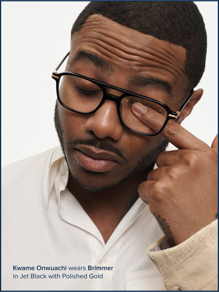 Person rubbing their eye through their eyeglasses.