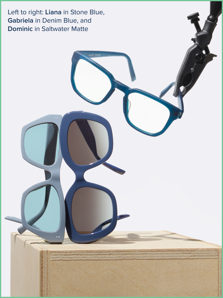 Stack of sunglasses, wile a blue frame is being holded by a clamp into the air.