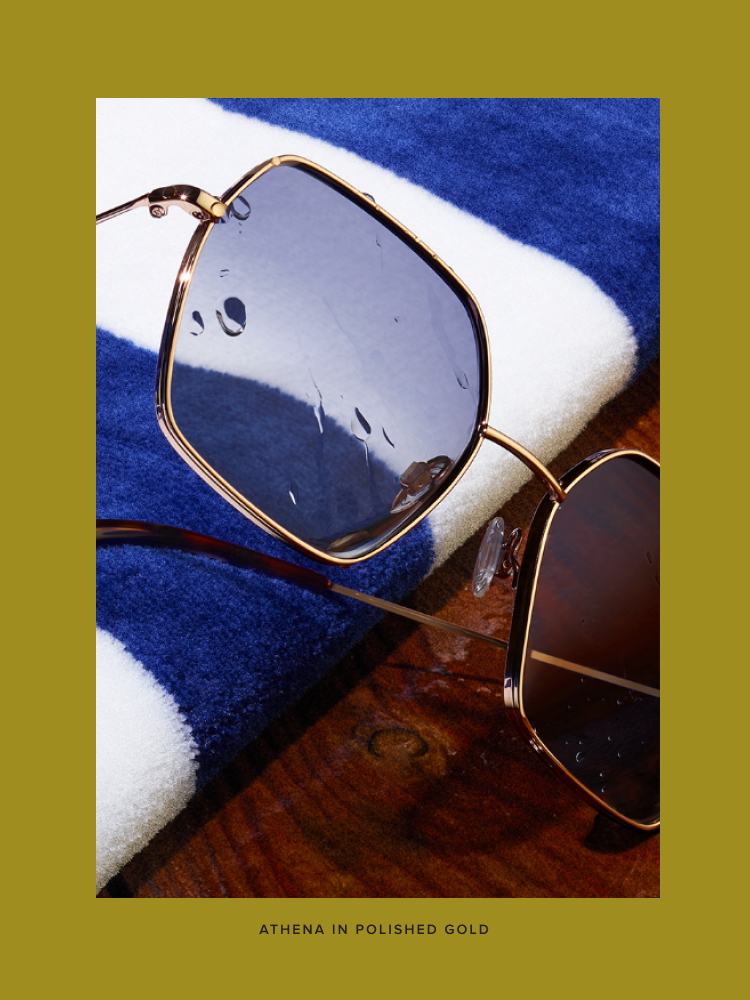 The Athena frame in Polished Gold sits on a deck.