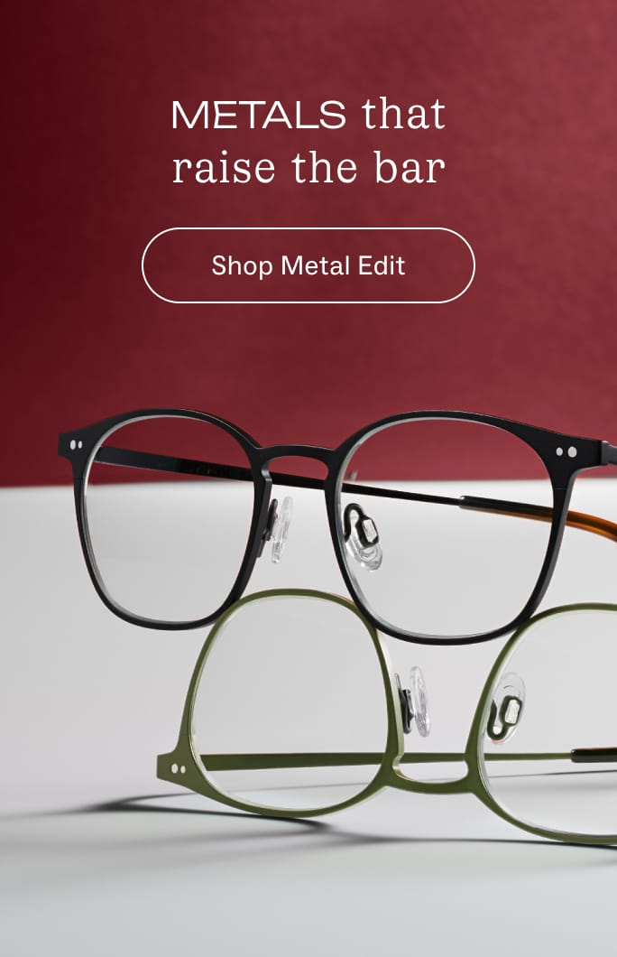 Black metal eyeglasses with round lenses are displayed on a textured brown surface.