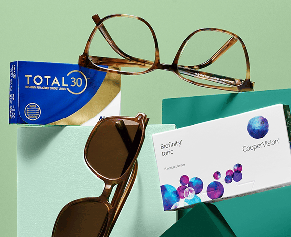 A pair of tortoise-shell glasses, sunglasses, and boxes of contact lenses on a light green background.