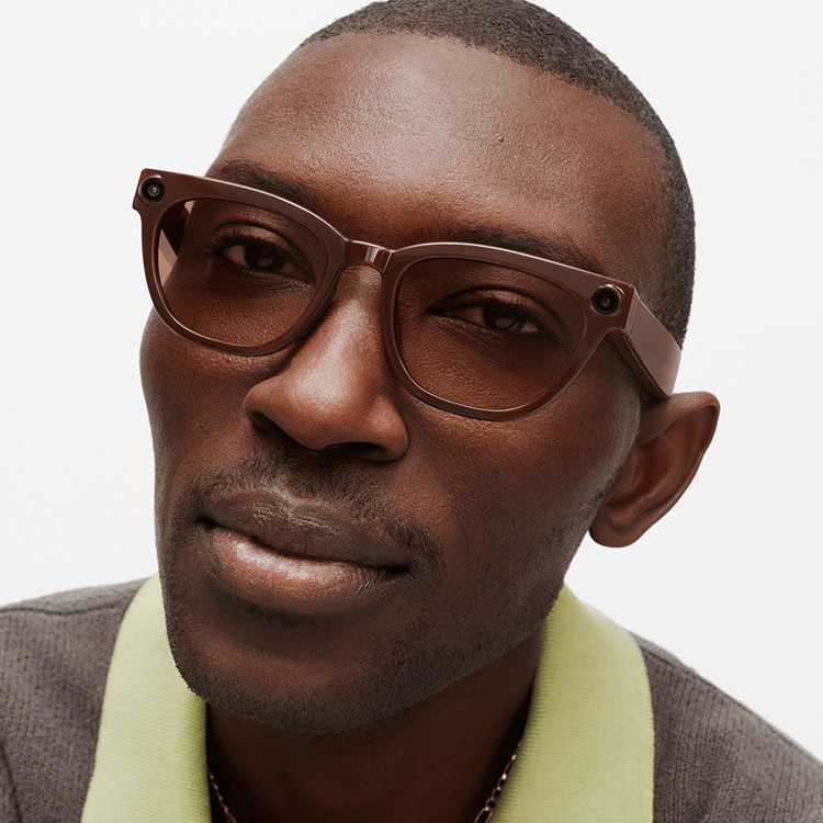 Close-up of a Black man wearing brown-framed glasses with cameras on the temples.