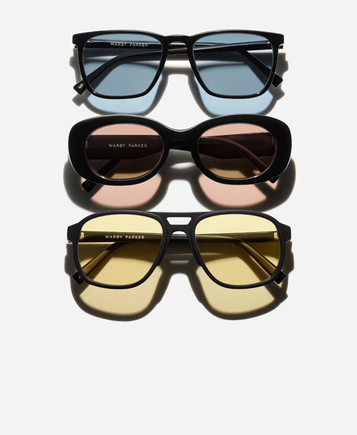 Three pairs of sunglasses, each with a different lens color: blue, pink, and yellow