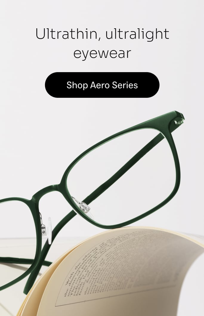 Ultrathin, ultralight eyewear - Shop Aero Series. A pair of dark green glasses rests on an open book.