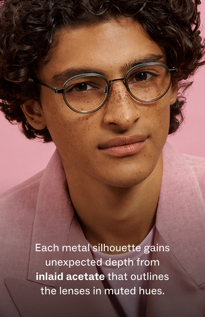 Man wearing glasses with metal frames and inlaid acetate detailing on the lenses.