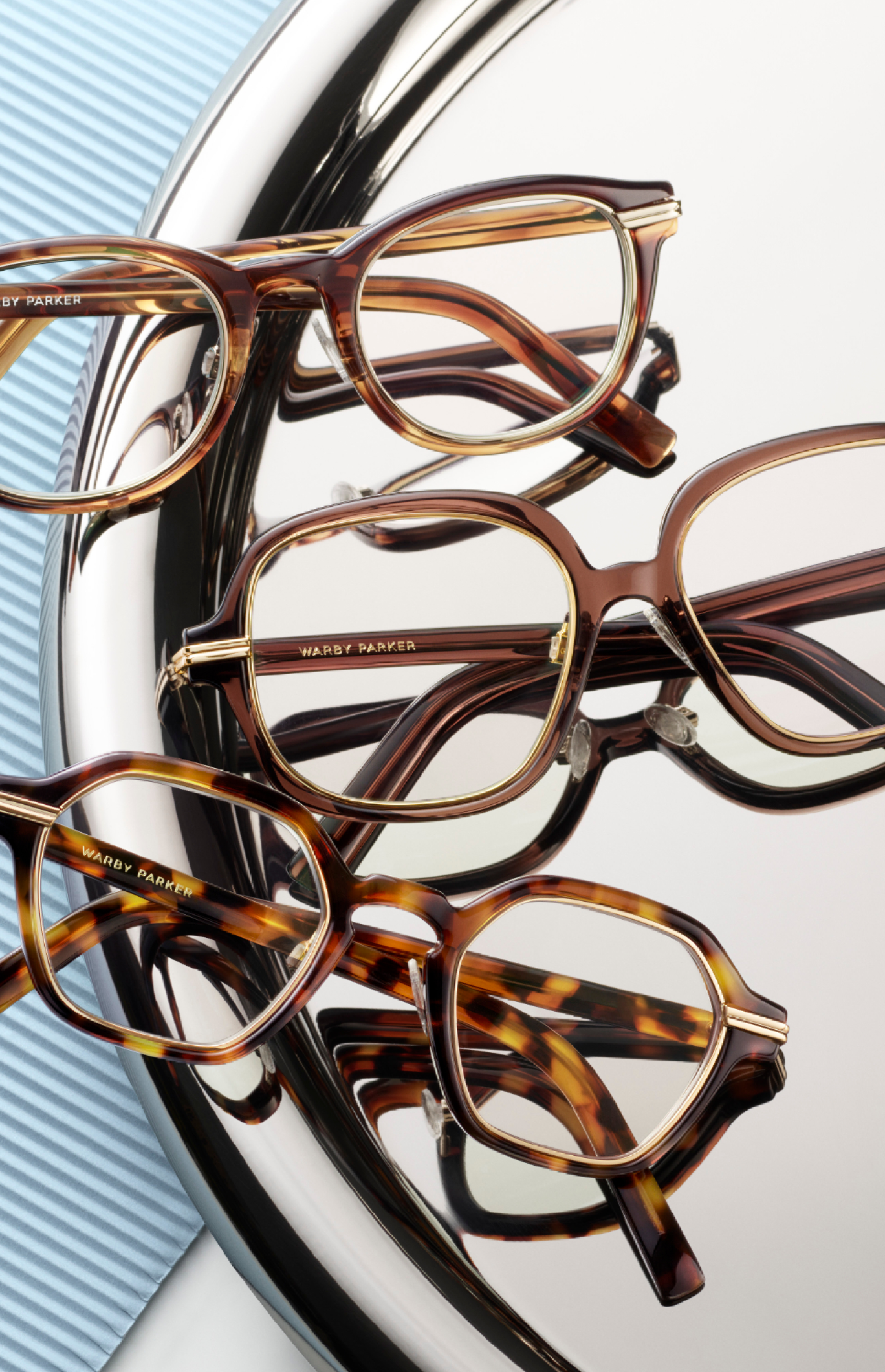A collection of eyeglasses with tortoise shell frames and clear lenses is artfully displayed.