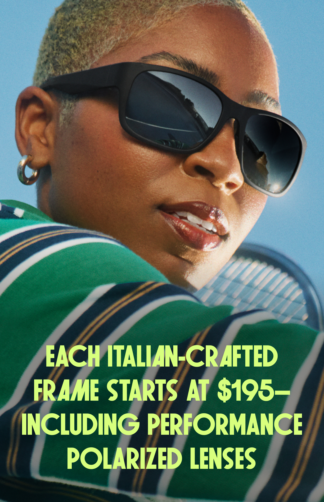 A woman wears oversized black sunglasses with a blue sky and green striped shirt.