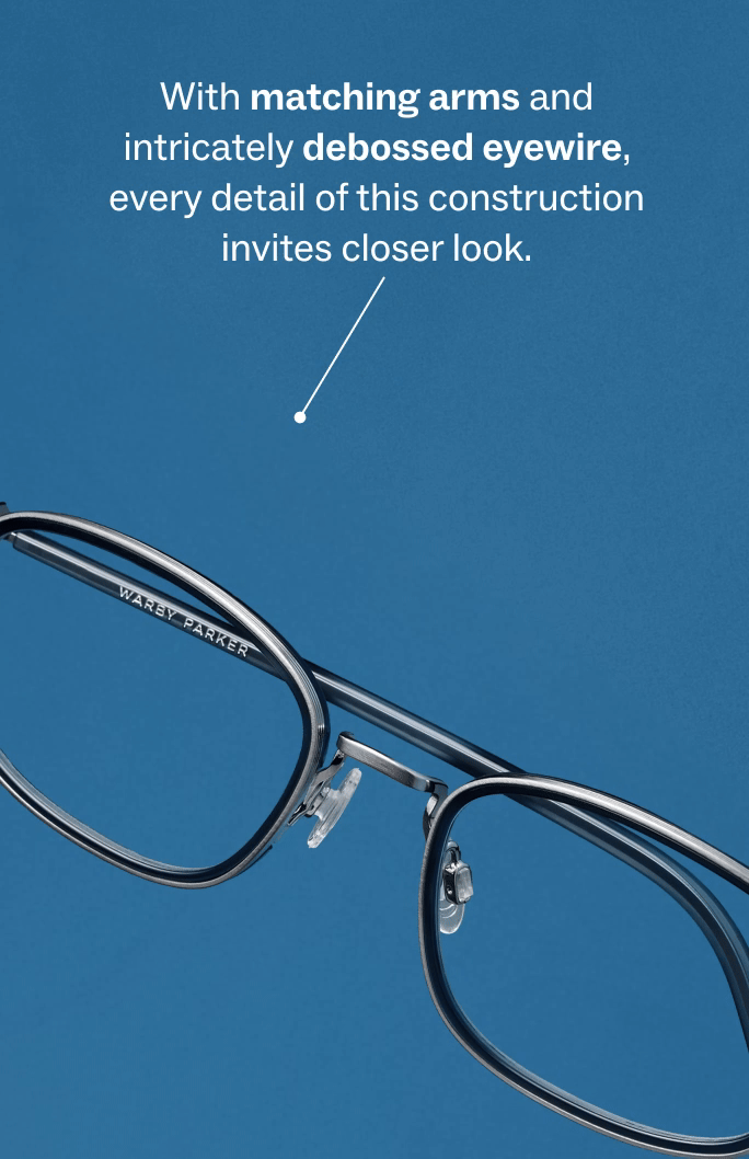 Close-up of eyeglasses with text that reads "With matching arms and intricately debossed eyewire..."