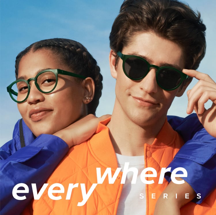 Female model smiling to the camera wearing eyeglasses and male model smiling to the camera wearing sunglasses. Logo for Everywhere Series collection.