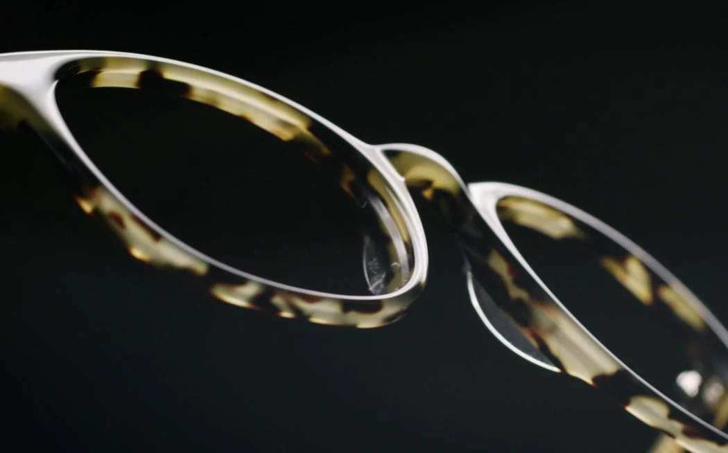 Floating yellow and black acetate frame front floating in mid air with a black background.