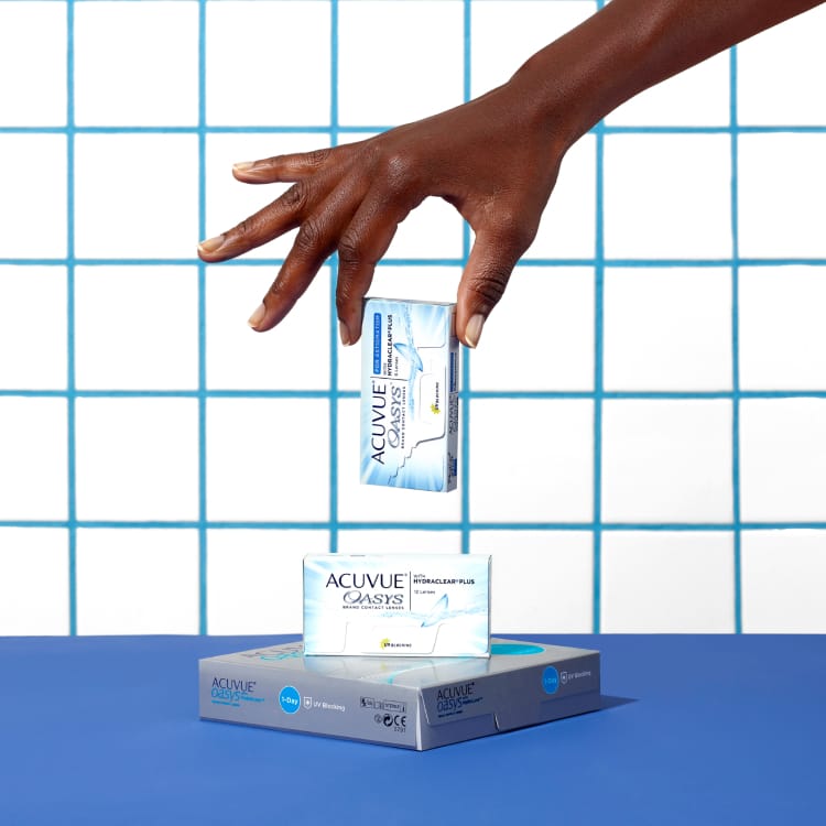 Hand posing with boxes of contact lenses