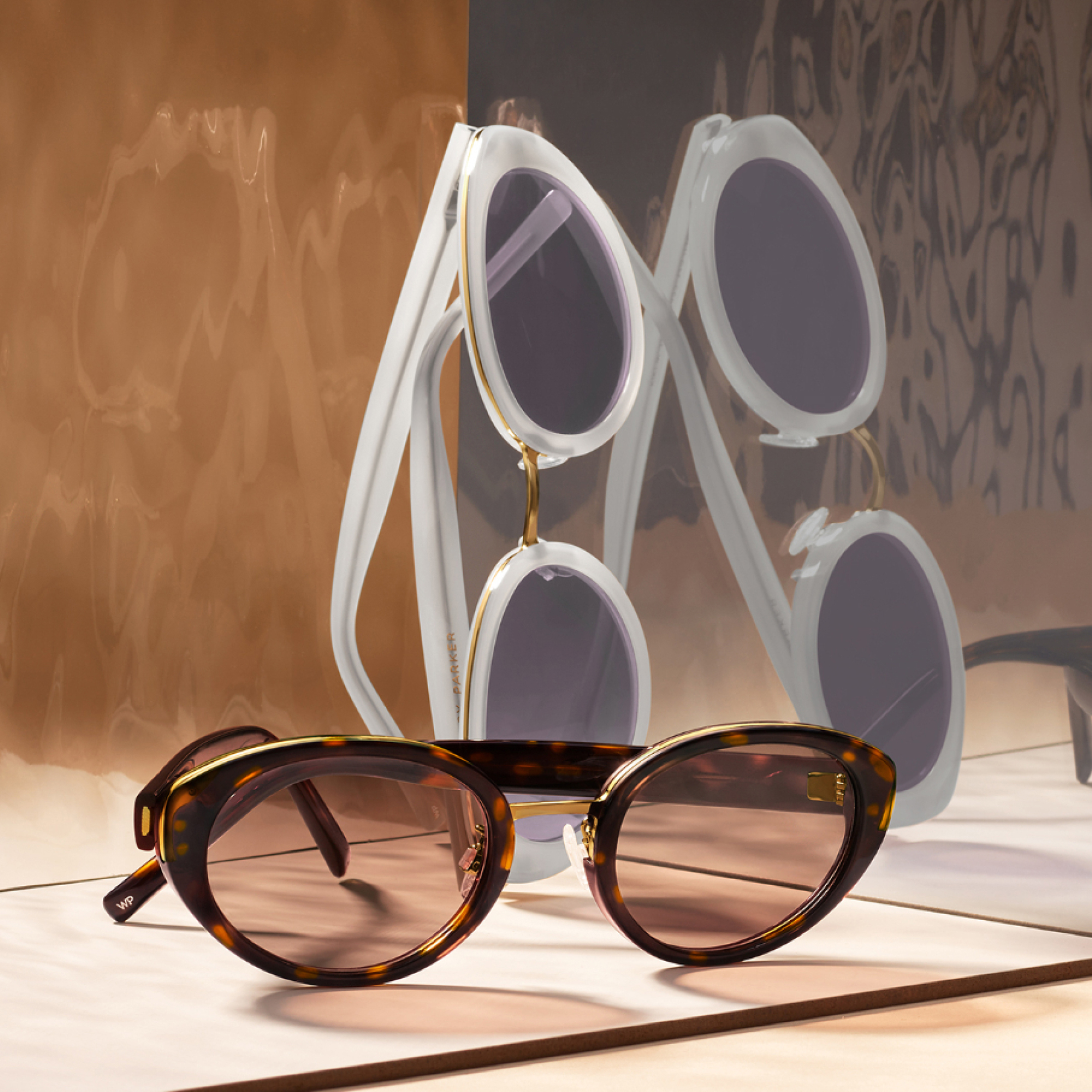 Entro collection sunglasses against a mirror.