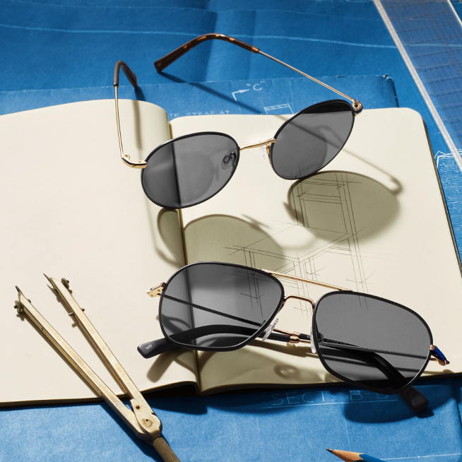 Glasses on top of drawings and notebook.