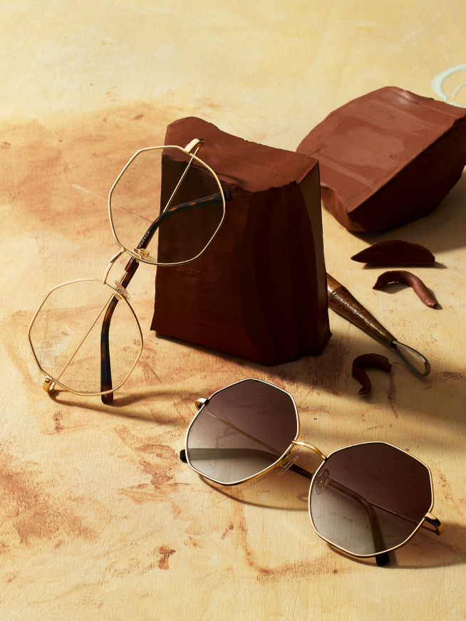 Frames and sunglasses resting on wood.