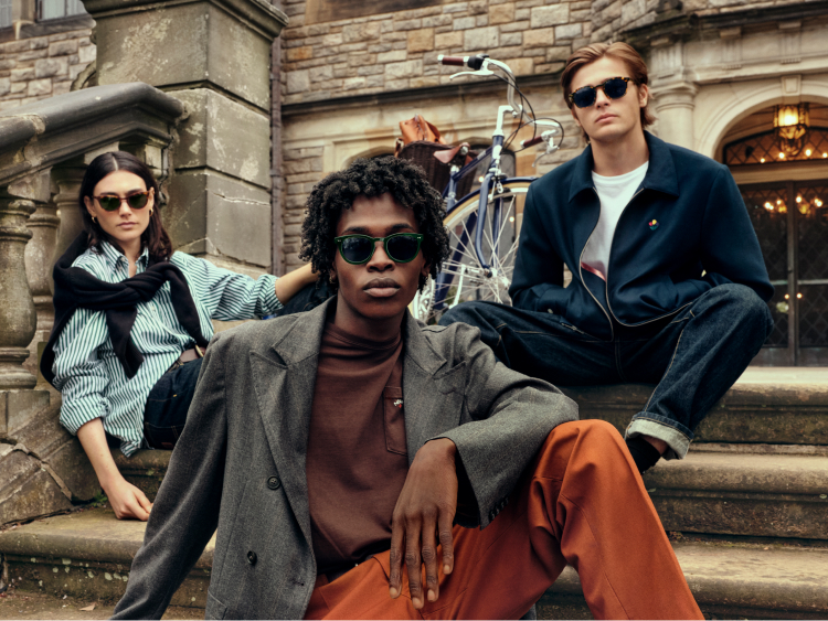 Student models wearing the Noah sunglasses collection while sitting on the front steps of the school