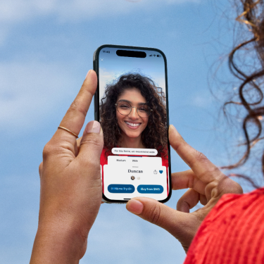 Girl smiling using cellphone camera.
