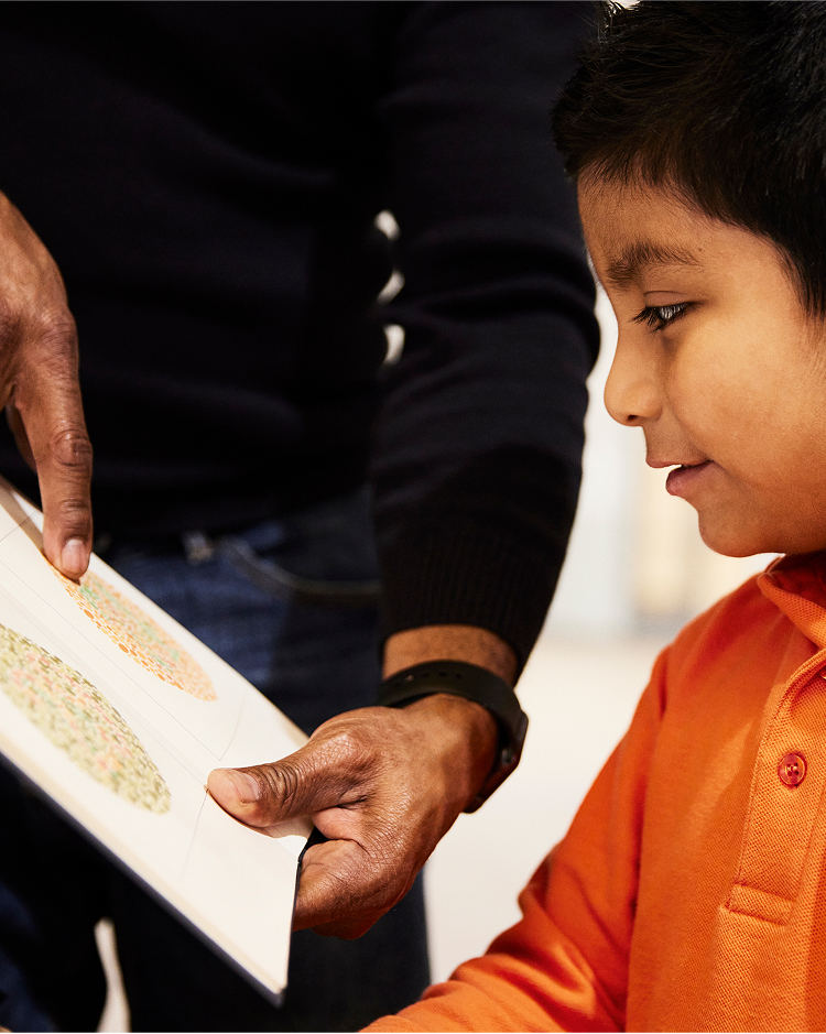 A kid taking a vision a test guided by an adult.