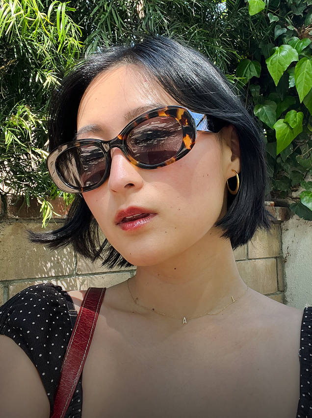 Woman wearing tortoiseshell, oval sunglasses