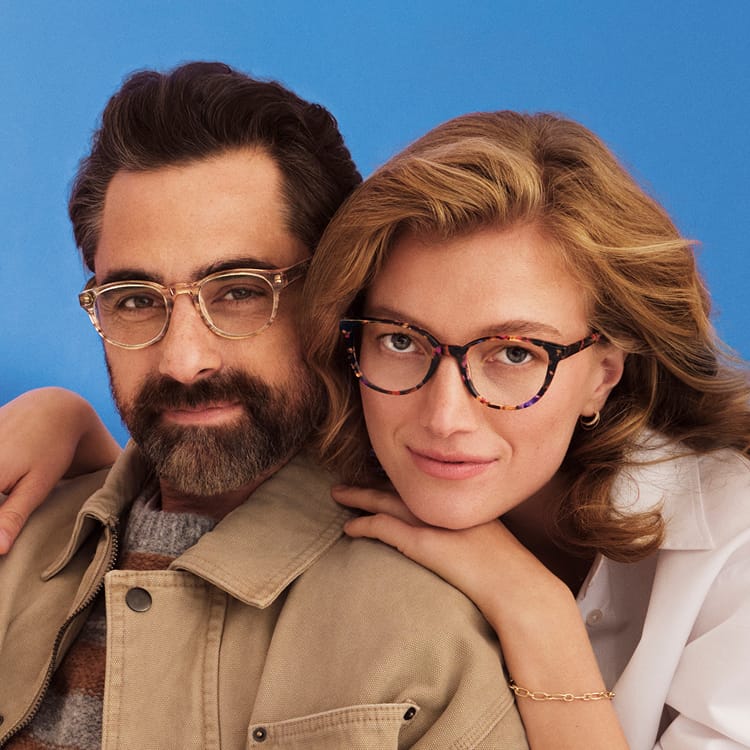 Man and woman with lenses smiling to the camera.