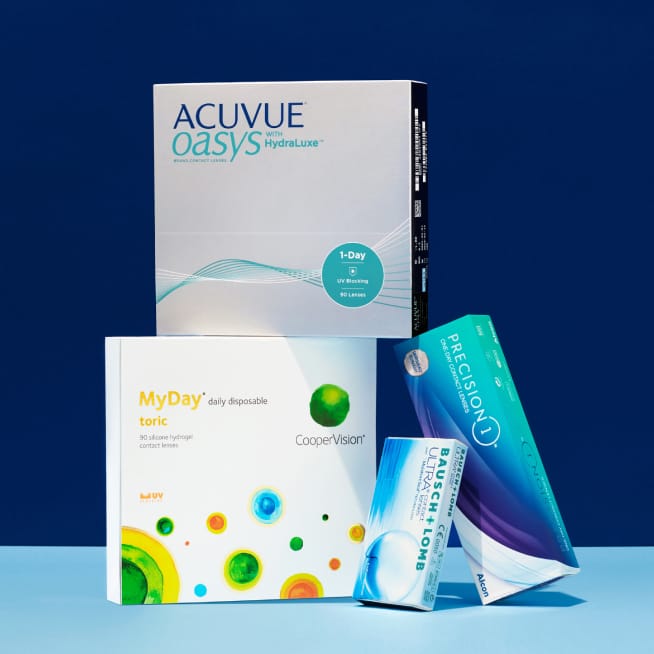 A stack of contact lens boxes from Acuvue, MyDay, Precision 1, and Bausch + Lomb.