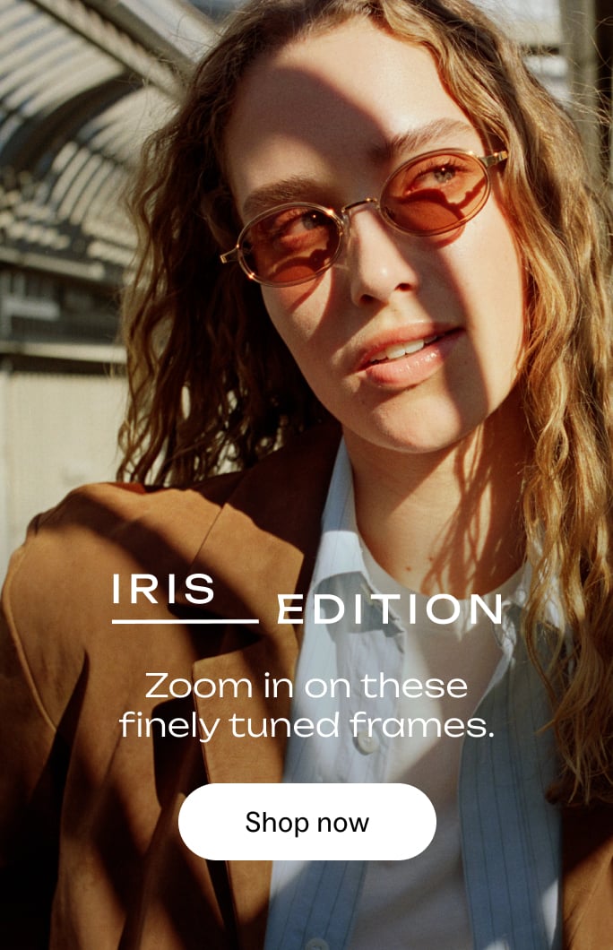A woman wearing oval, tinted sunglasses and a brown blazer, with text overlay.
