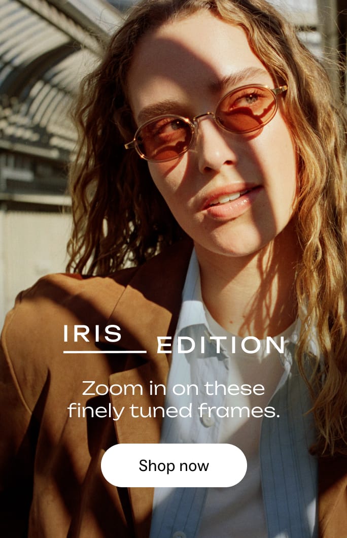 A woman wearing oval, brown-tinted sunglasses and a brown blazer.